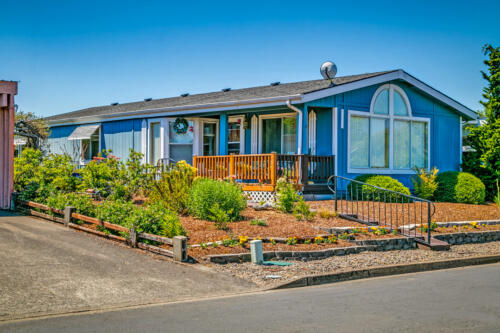 A blue mobile home in a residential neighborhood.