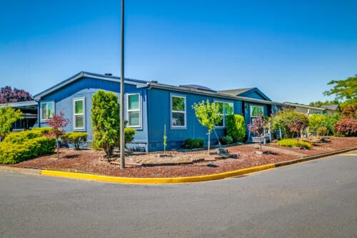 A blue mobile home in a residential neighborhood.